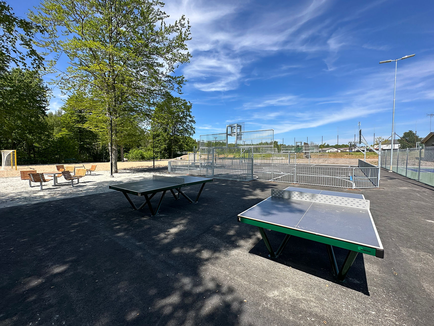 Utendørs bordtennisbord med en ballbinge i bakgrunnen 