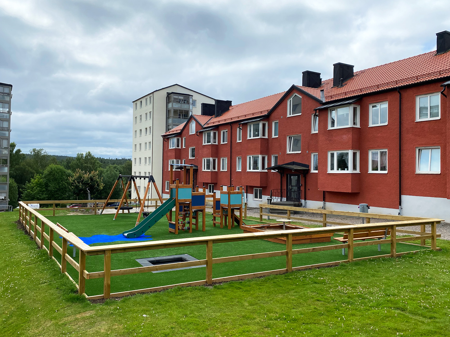 Lekeplass med lekeapparater og husker i boligområde 