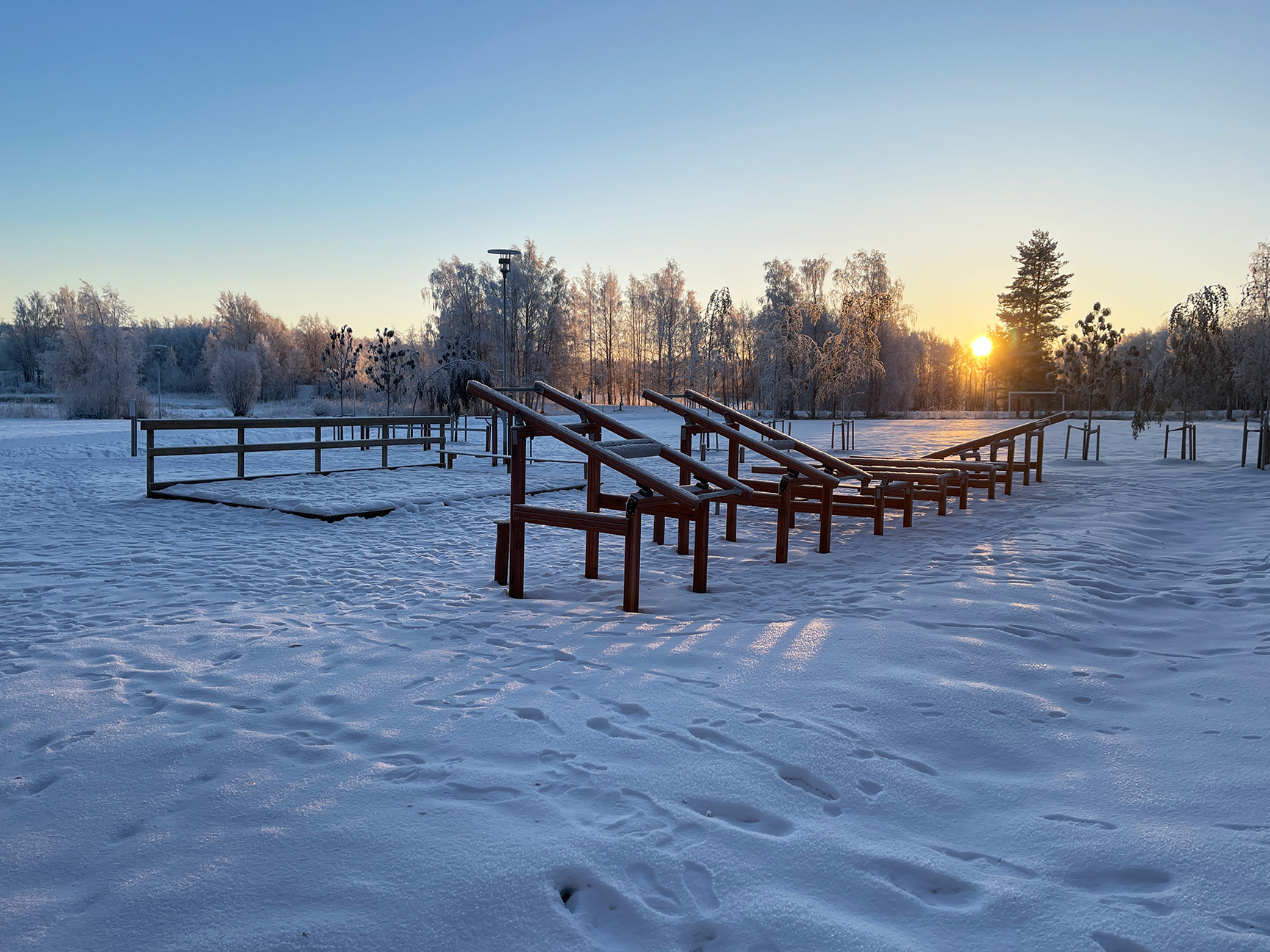 Utegym i snøen ved solnedgang.